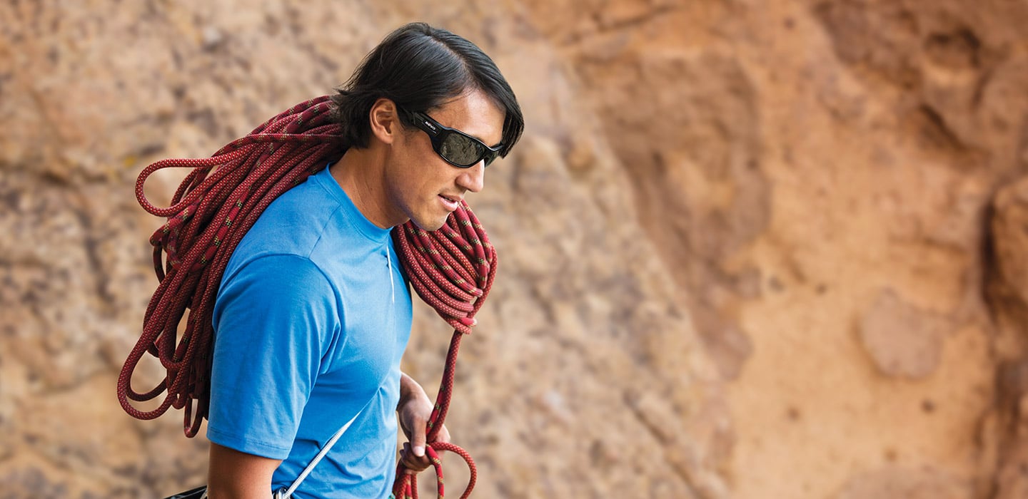 Climber Blue Shirt Sunglasses Carrying Rope on Shoulder