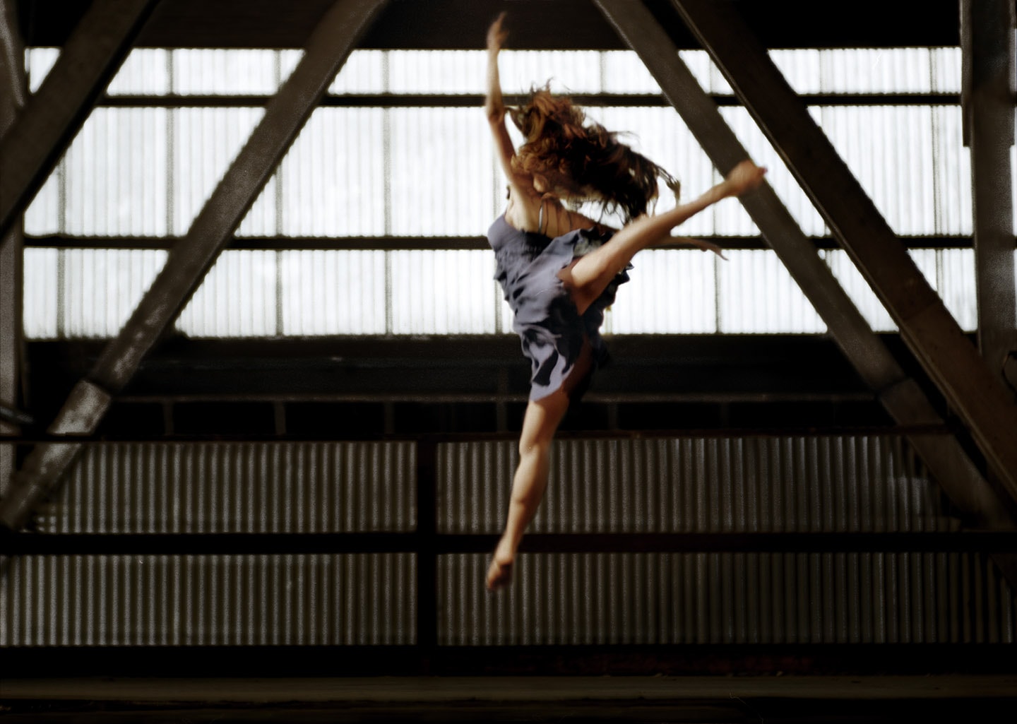 Dancer In Blue Blurred Profile Image Arabesque Jump Leg Raised Mid Air