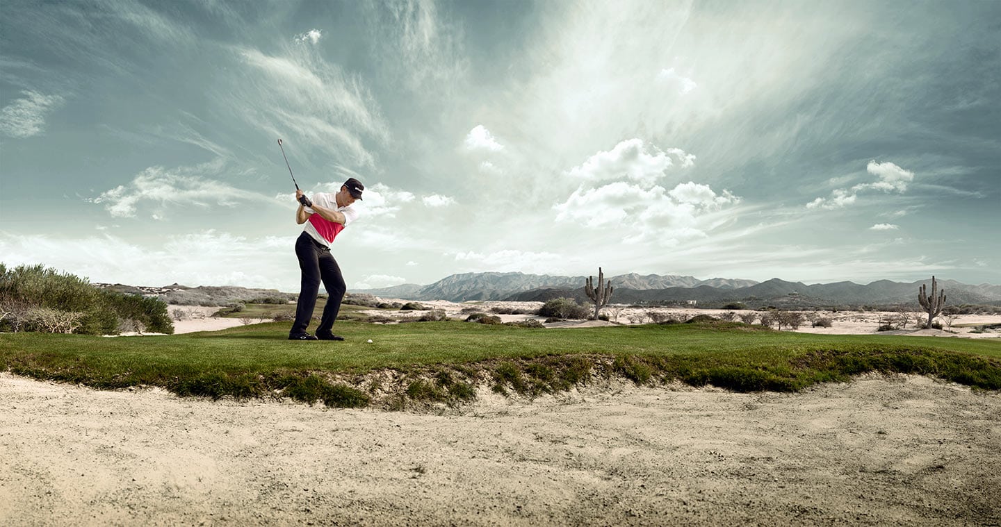 Image of Man in Mid Golf Swing on Golf Range Against Background of Bright Grey Skies