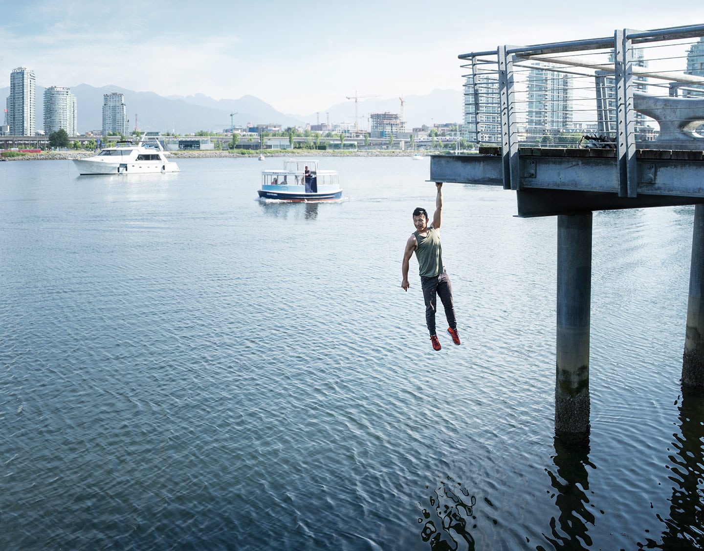 Parkour Athlete Hanging Over Blue Water Front Image City Skyline