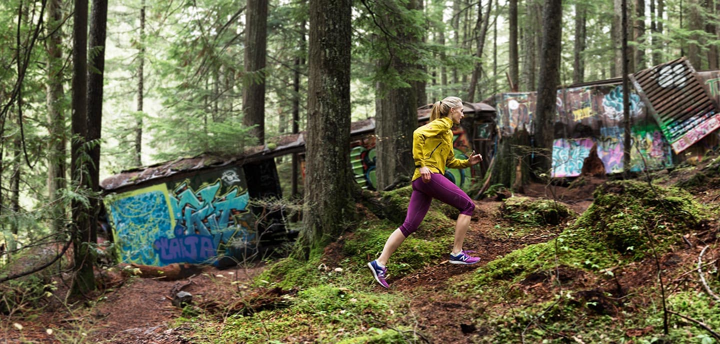Woman in Yellow Jacket and Purple Capris Running In Forest Past Graffiti RodMcLean