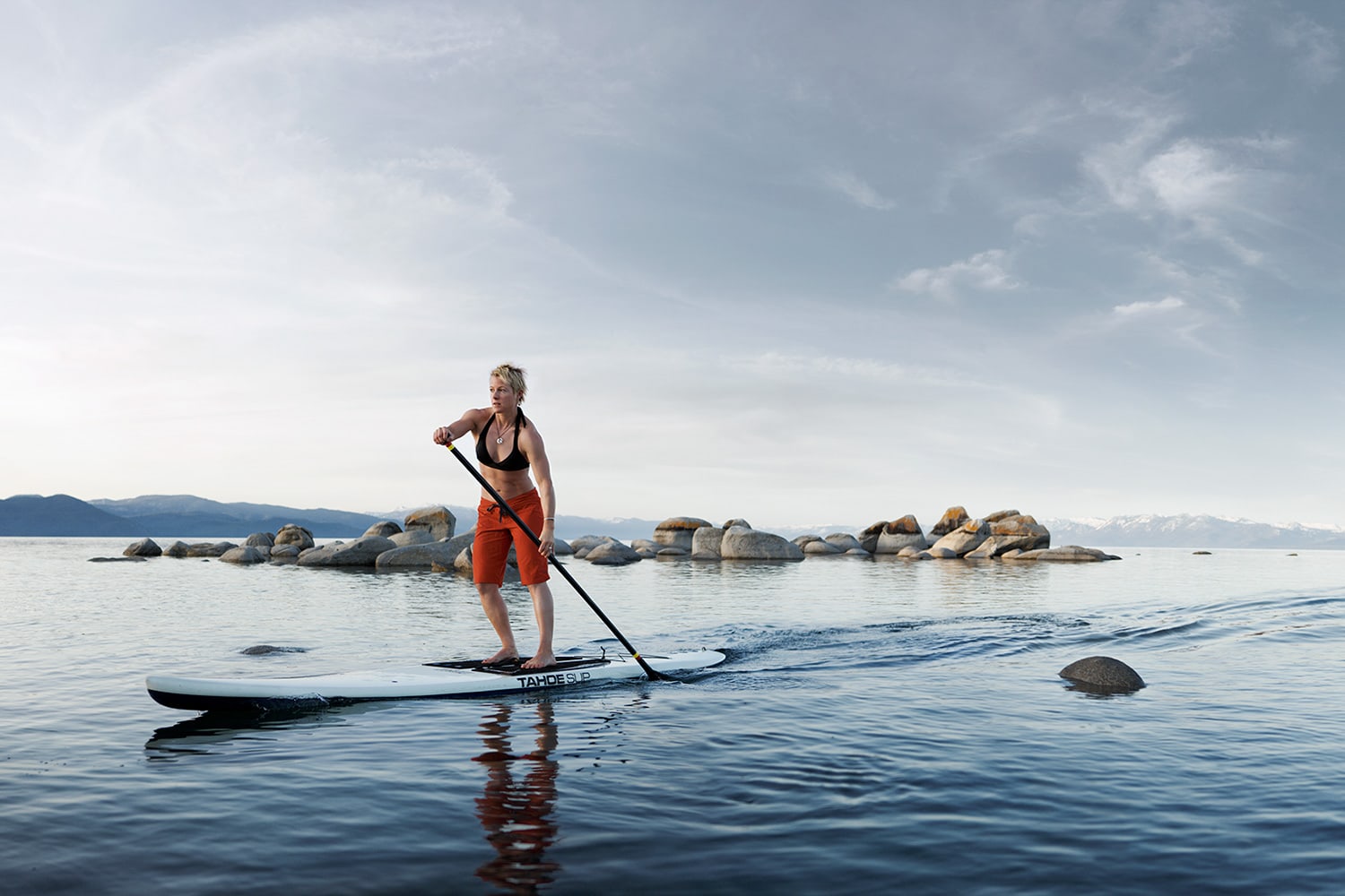 Active-Lifestyle-woman-paddle-boarding-on-lake-rocks-Rod-McLean