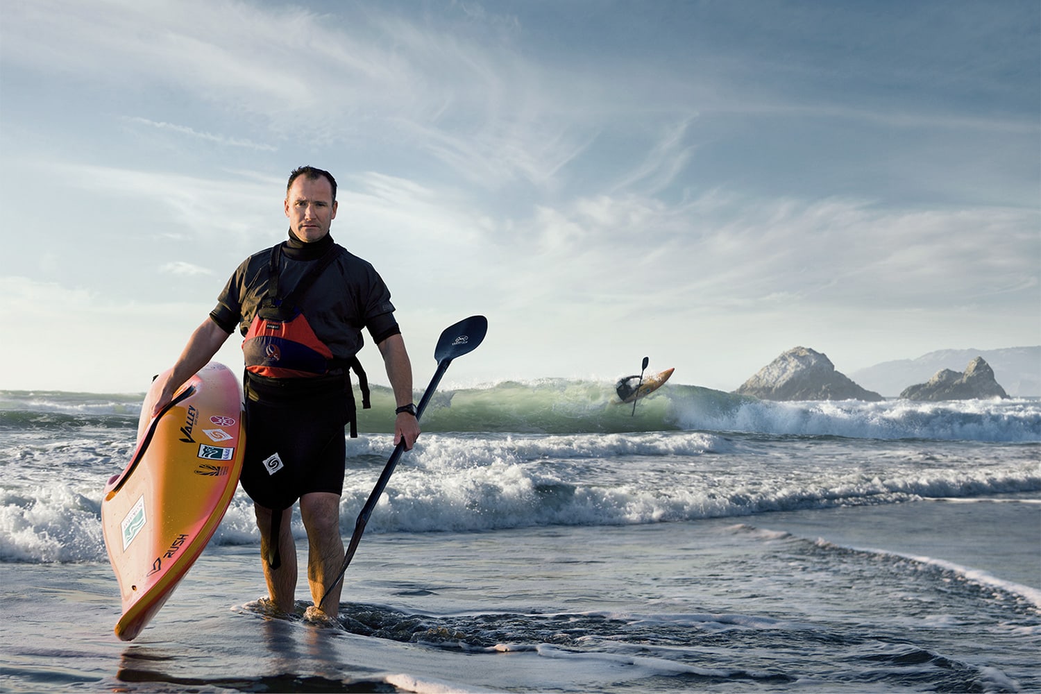 Athlete-Man-holding-a-kayak-and-paddle-at-the-beach-waves-Rod-McLean