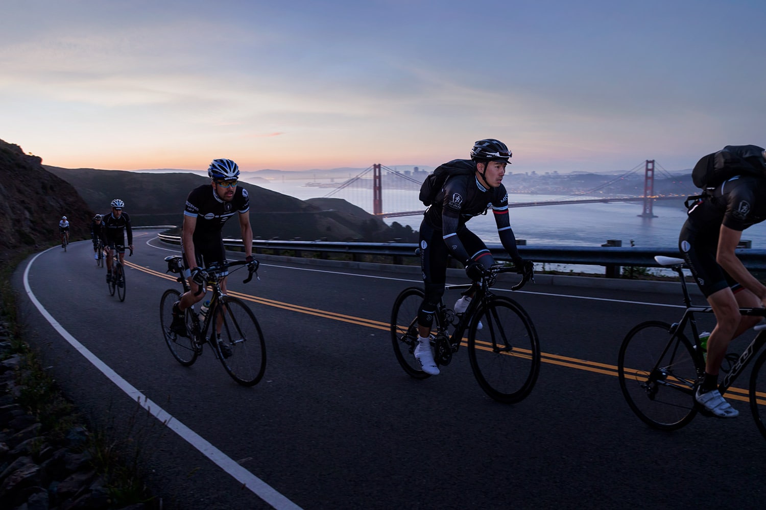 Athletes-Cyclists-ridding-up-hill-with-golden-gate-bridge-and-city-Rod-McLean