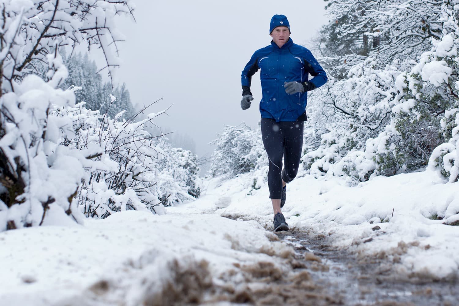 Athletic-lifestyle-Man-running-on-muddy-path-in-a-snow-storm-Rod-McLean