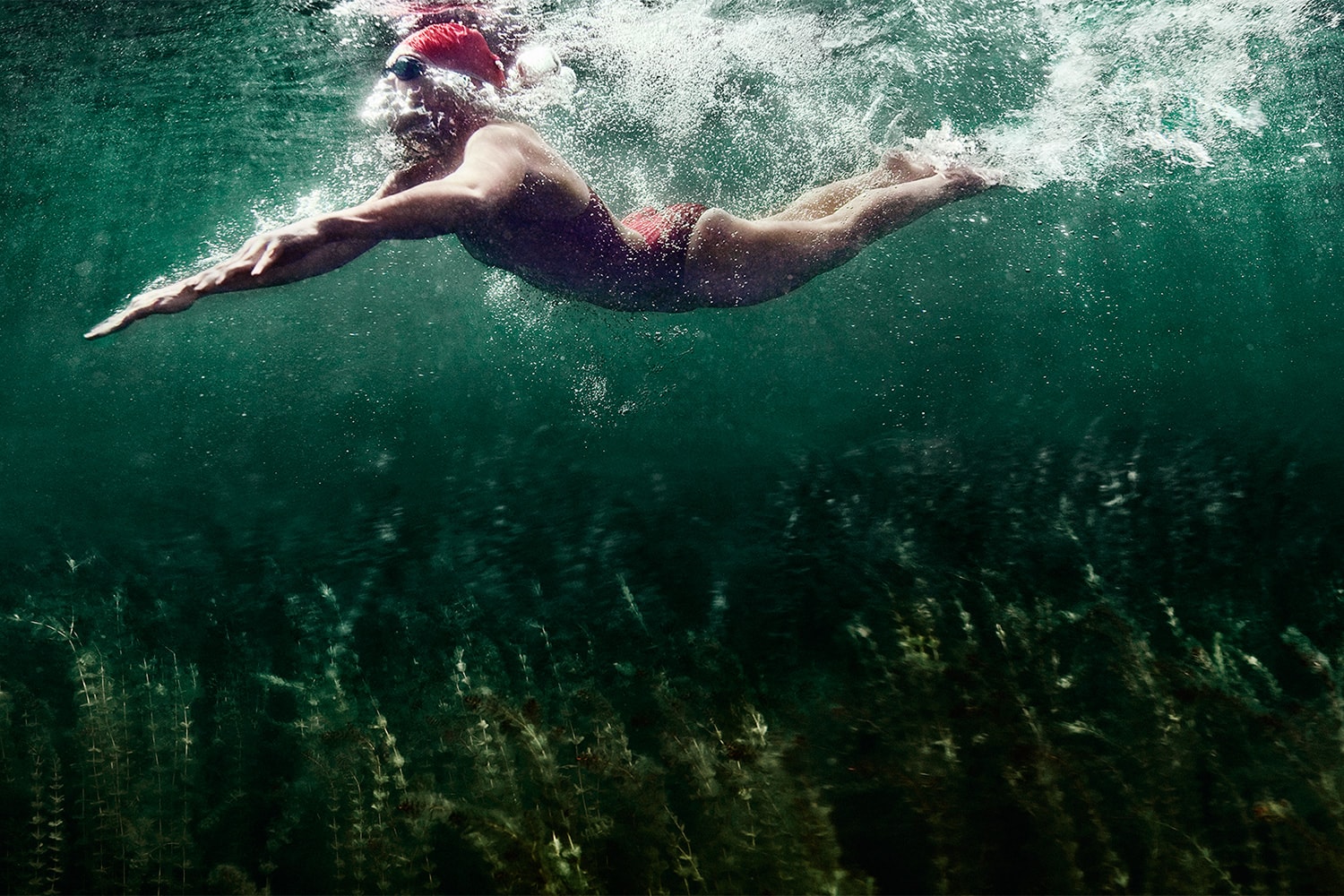 Athletic-lifestyle-female-swimming-red-suit-bluegreen-water-Rod-McLean